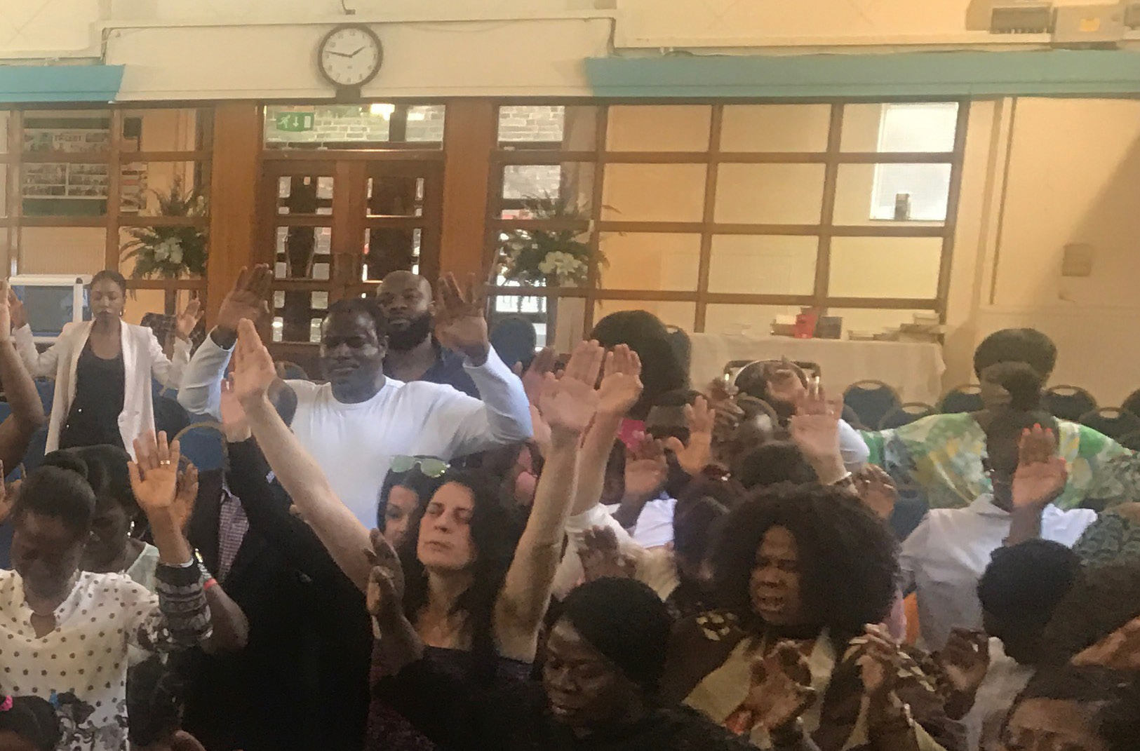 A congregation worshipping together in a church hall